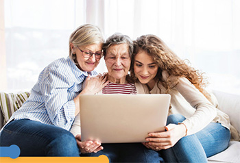 three generations of women looking at a laptop